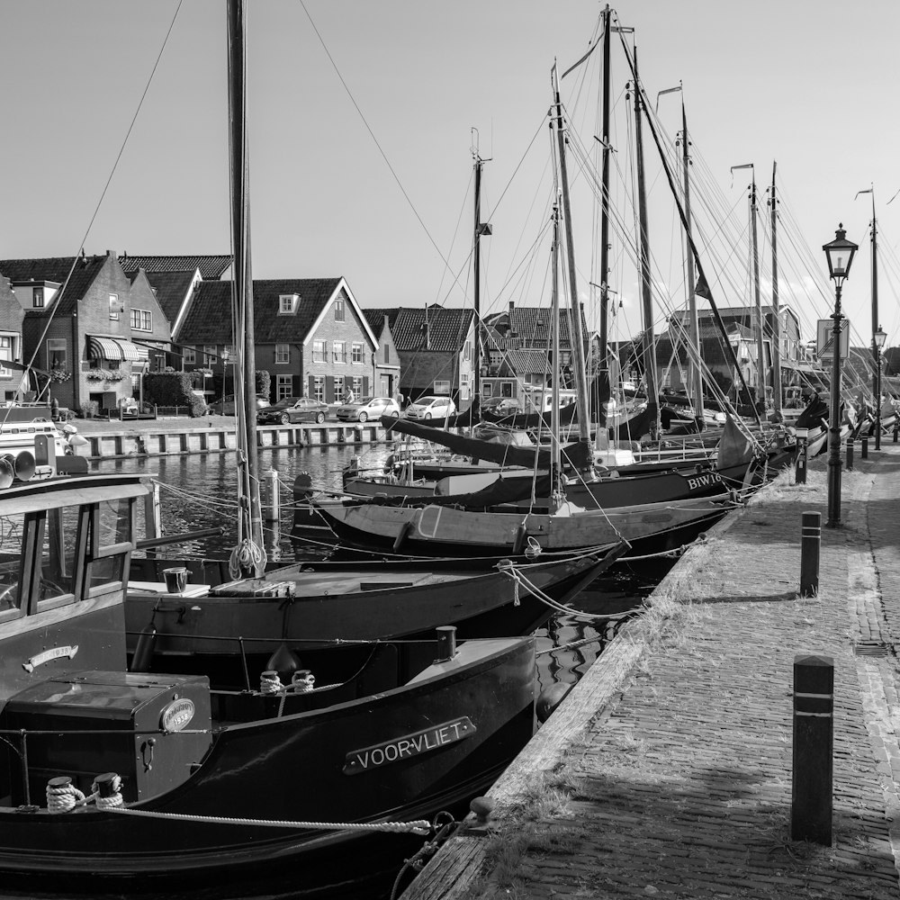 a black and white photo of boats docked at a pier