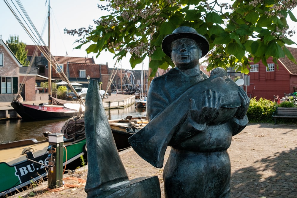 a statue of a man holding a bucket near a body of water