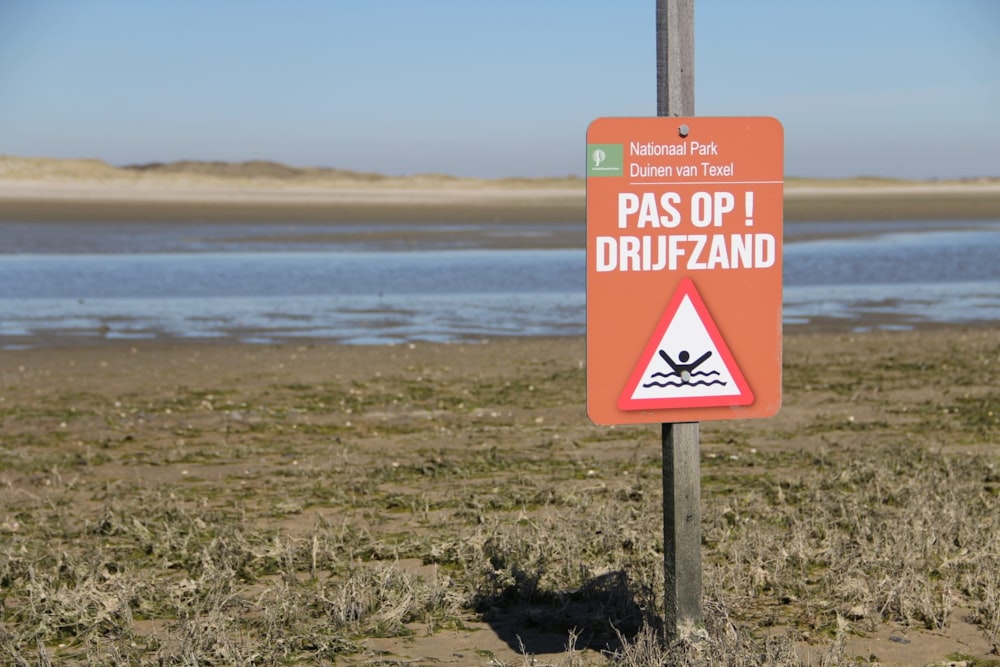 a sign on a pole in the middle of a field