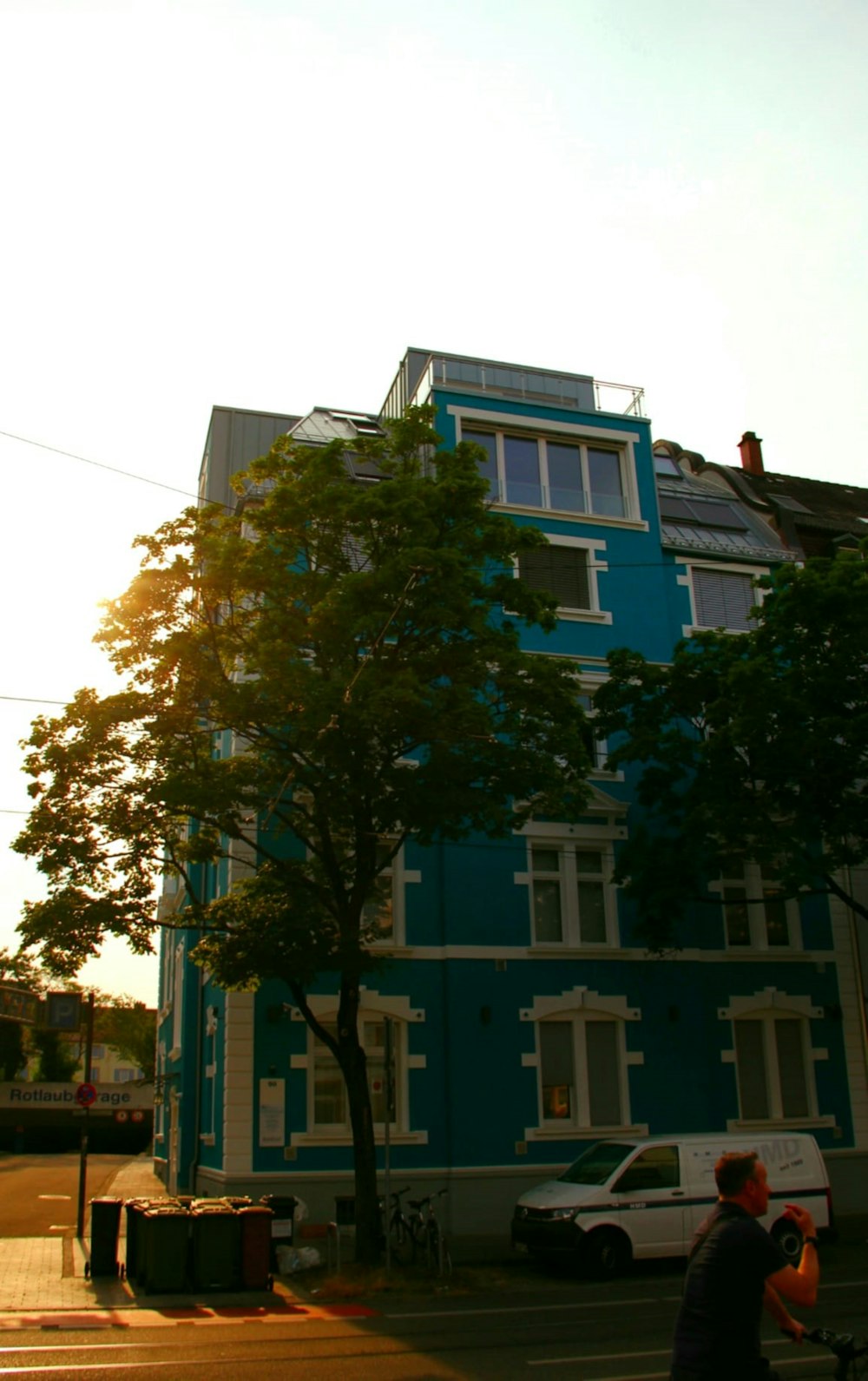 a man walking down a street next to a tall blue building