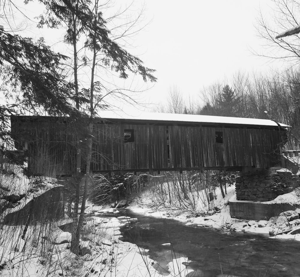 a black and white photo of a covered bridge