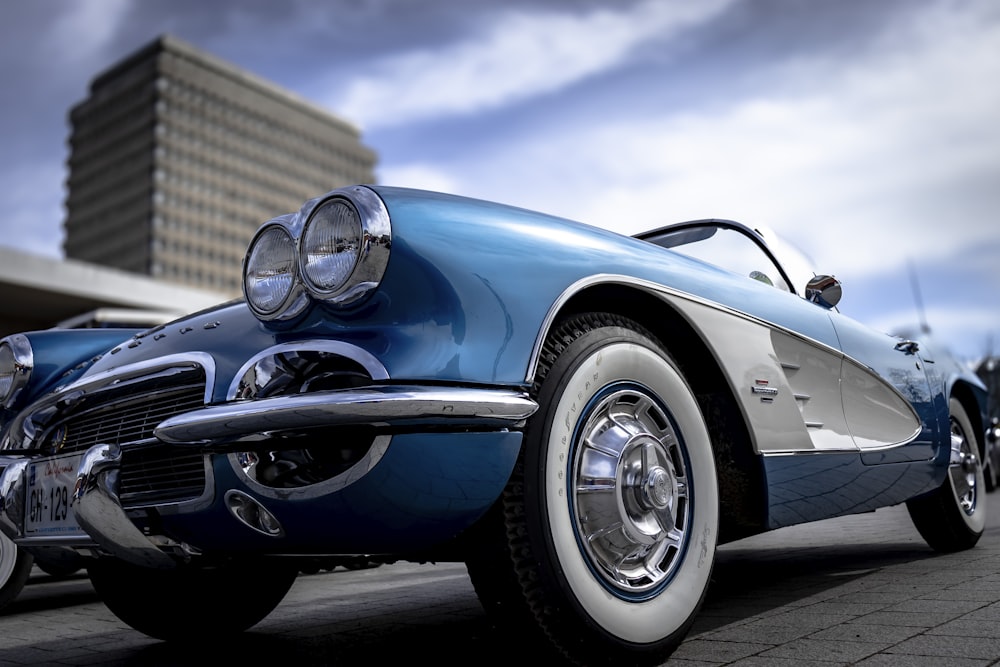 a blue and white car parked on the side of a road