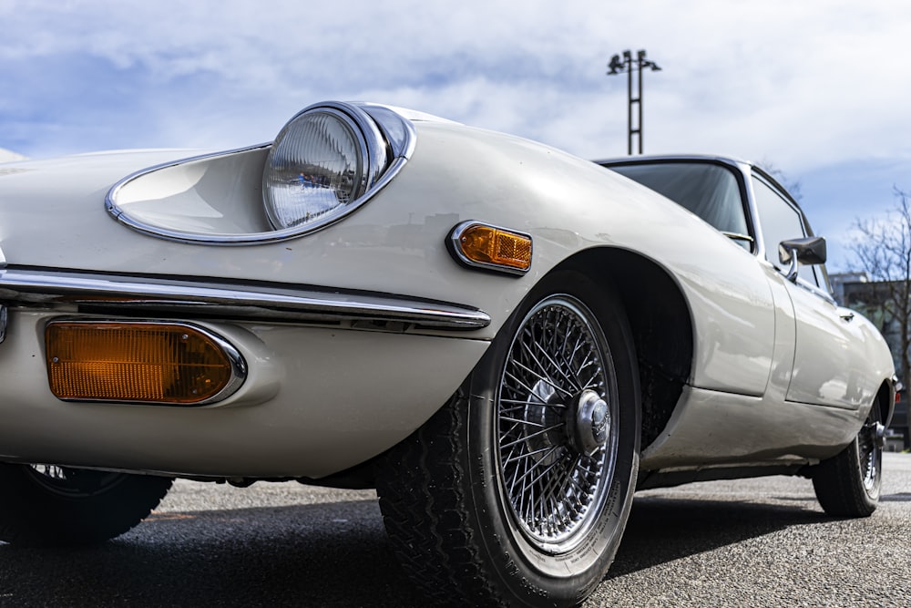 a white sports car parked in a parking lot