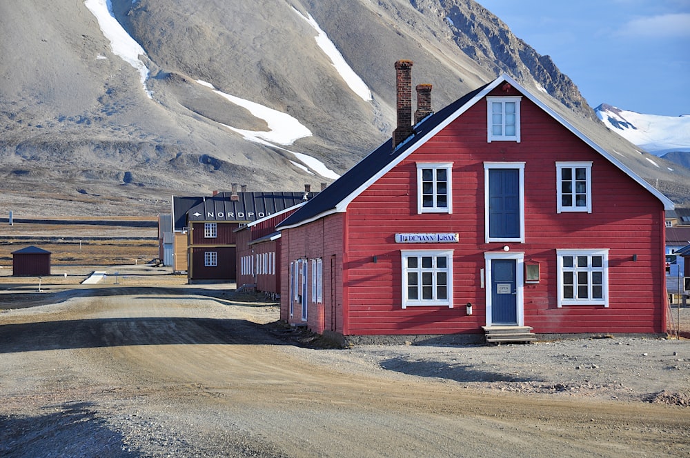 a red building sitting on the side of a dirt road