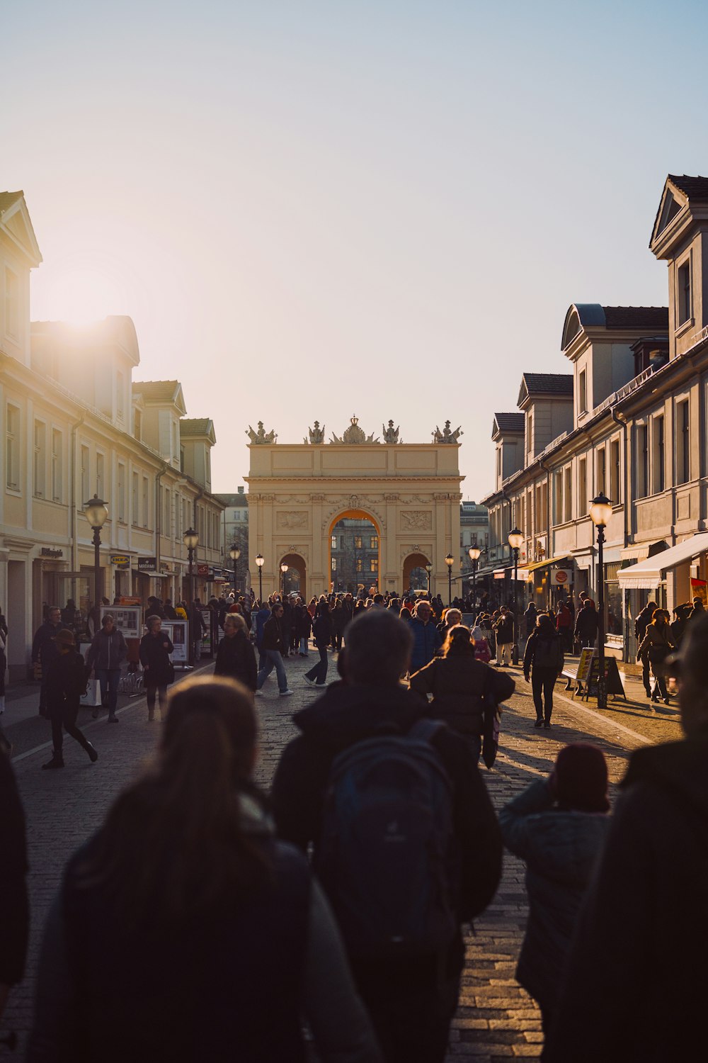 a crowd of people walking down a street next to tall buildings