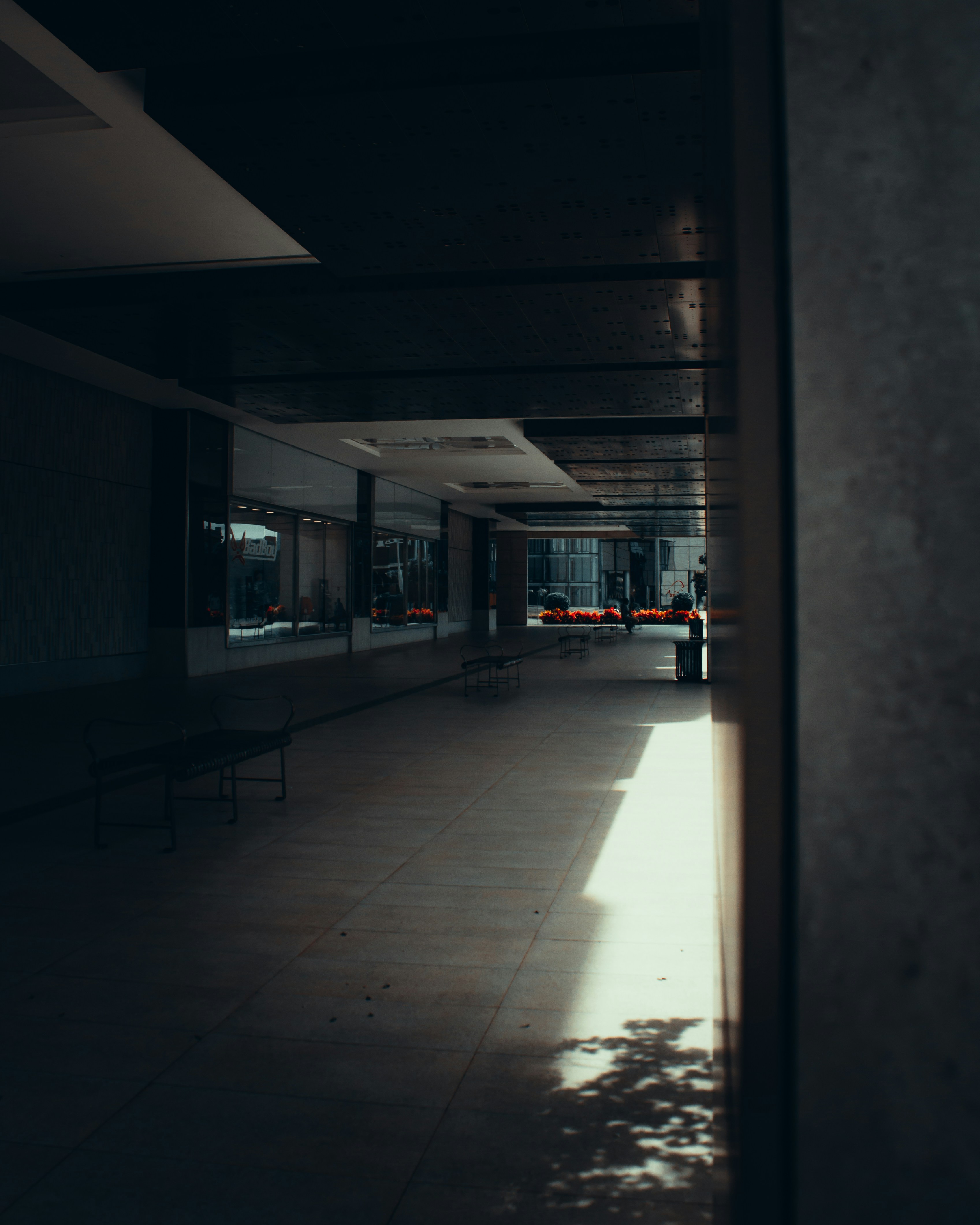 a dark hallway with benches and a window
