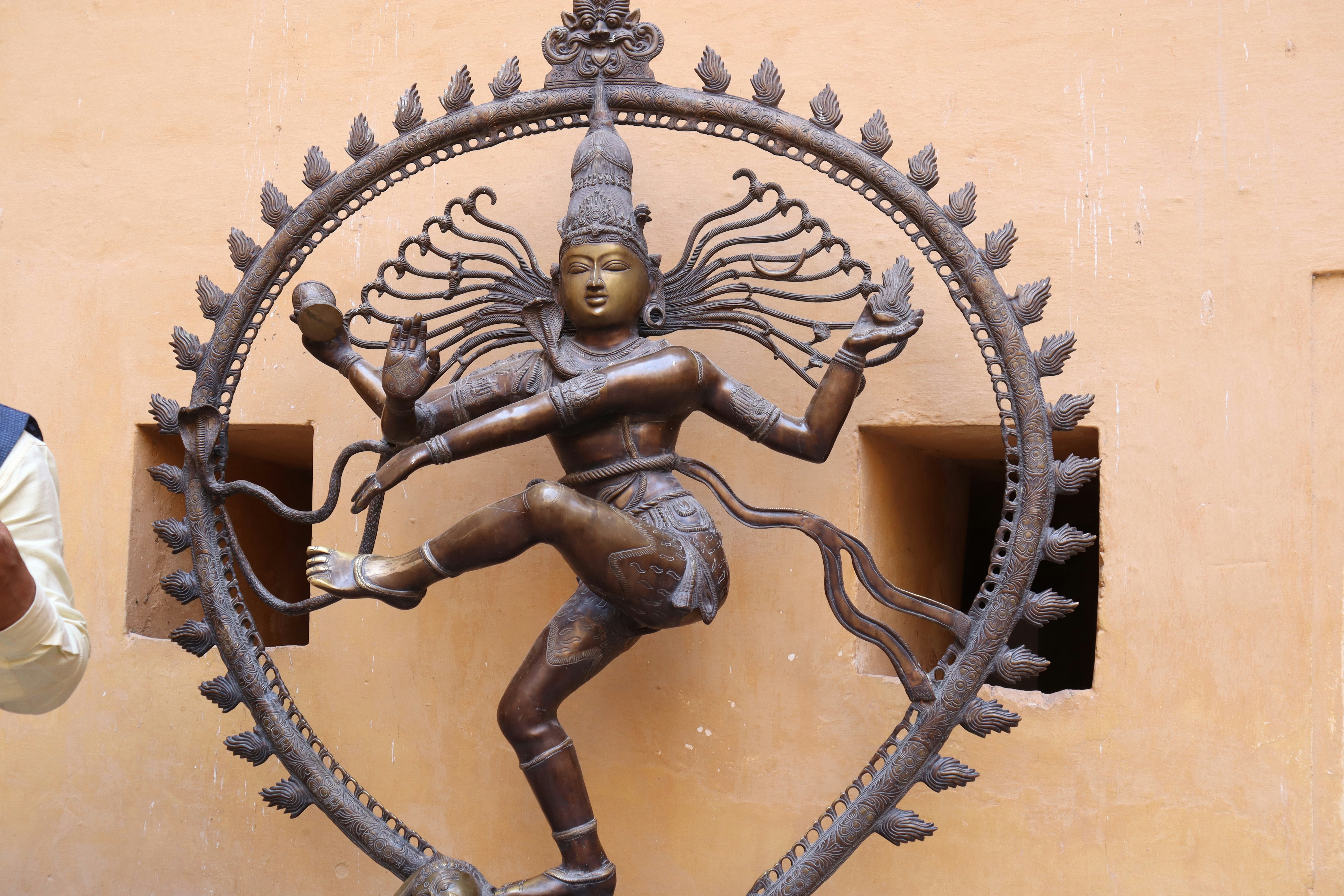 Bronze Nataraja sculpture with intricate detail, dramatic museum lighting, dark background, golden highlights