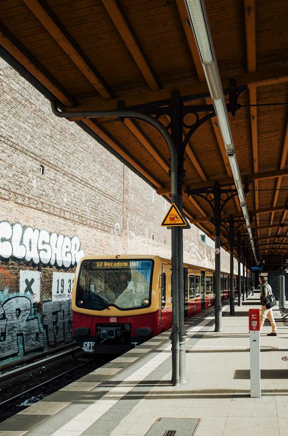 a train pulling into a train station covered in graffiti