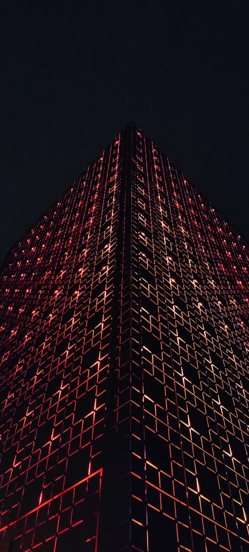 a very tall building lit up with red lights