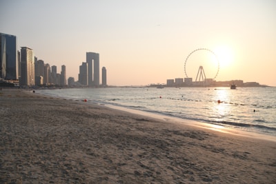 a beach with a ferris wheel in the background