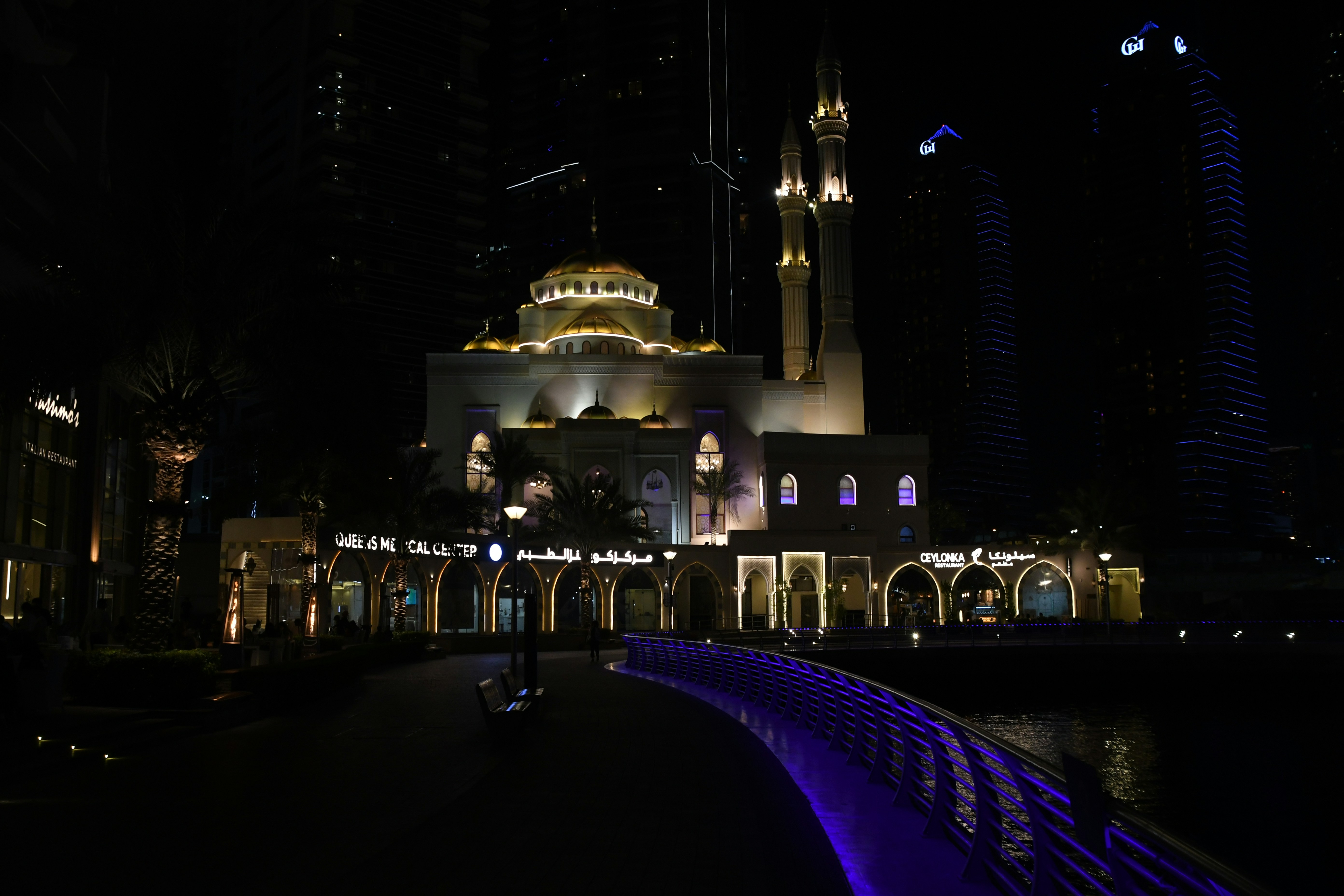 a building lit up at night with a fountain in front of it