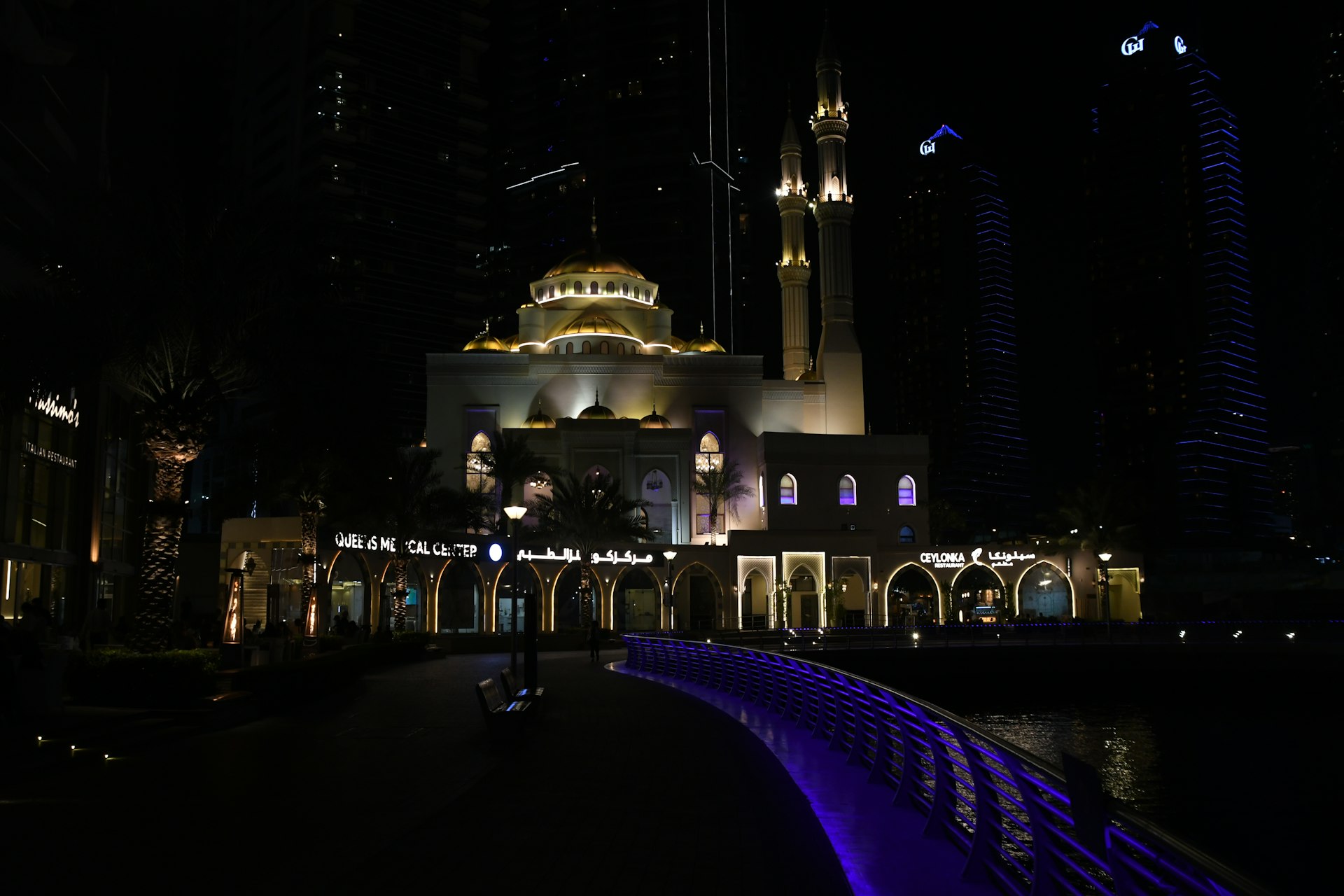 a building lit up at night with a fountain in front of it
