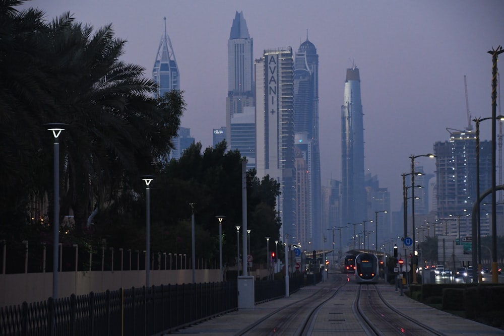 a train on a track in front of a city skyline