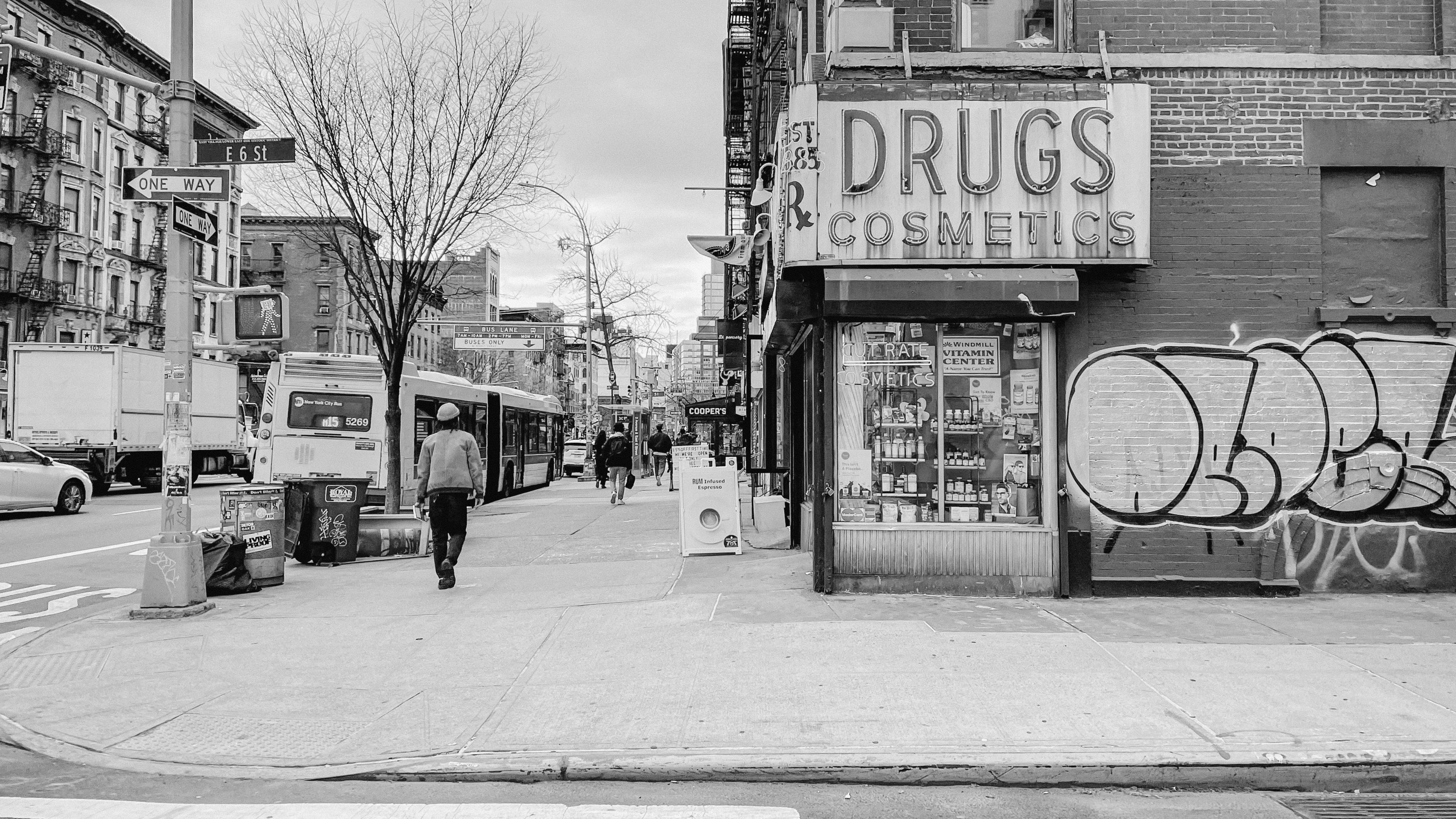 a black and white photo of a man walking down a street