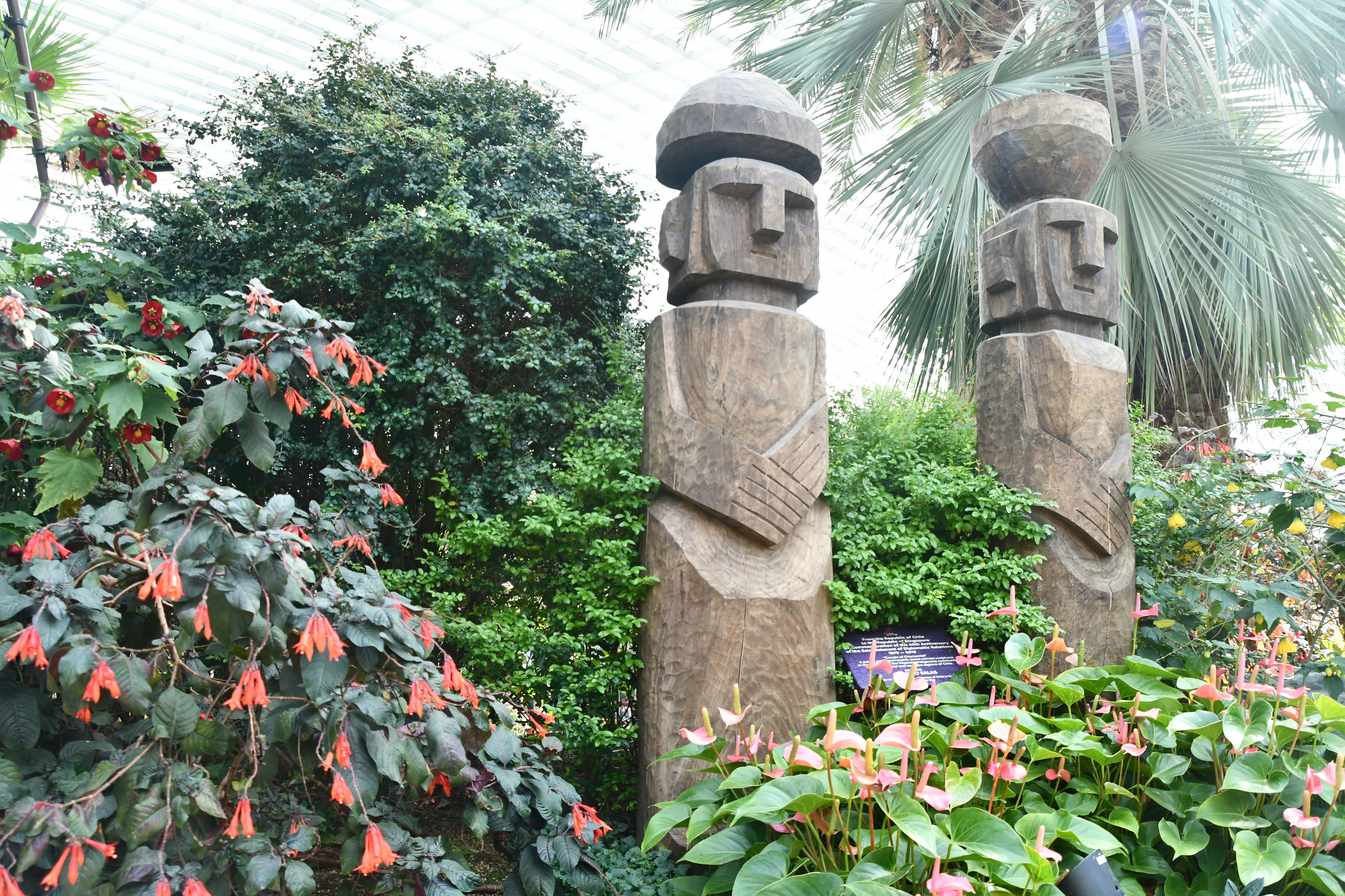 um par de estátuas sentadas uma ao lado da outra em um jardim