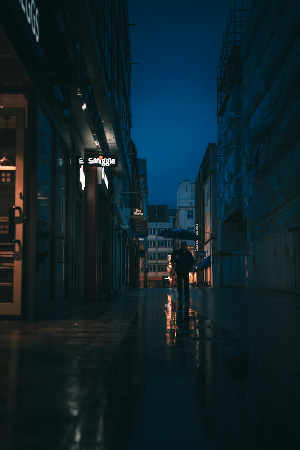 a person walking down a street at night