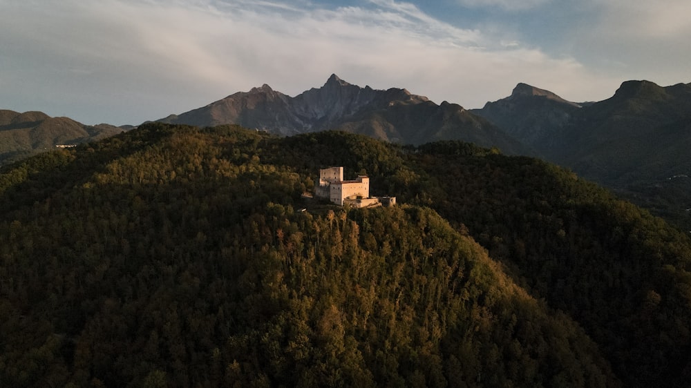 a house on a hill with mountains in the background