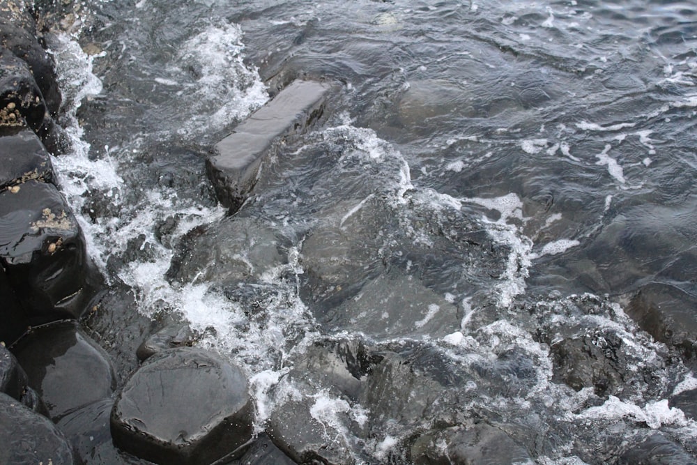 the water is rushing over the rocks in the water