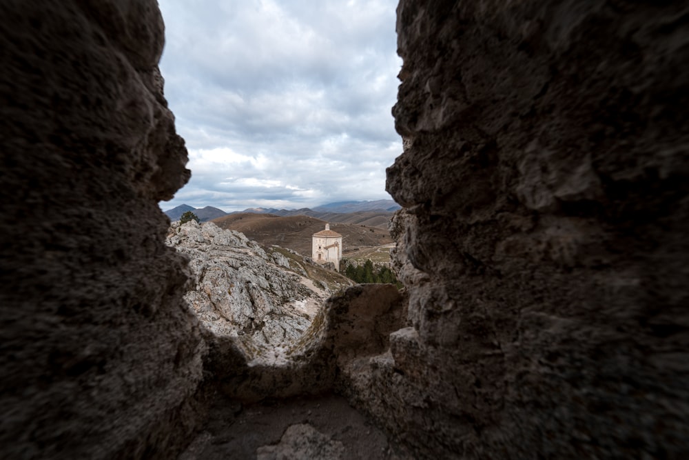 a view of a castle through a hole in a rock wall