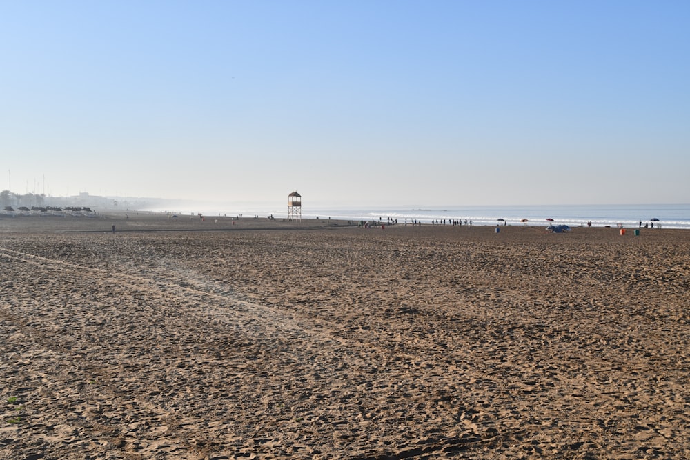 a sandy beach with people walking on it