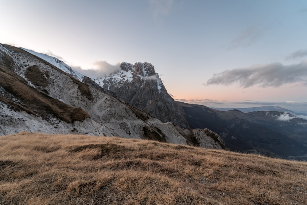 a grassy hill with a mountain in the background