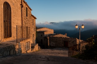 a cobblestone street leading to a stone building