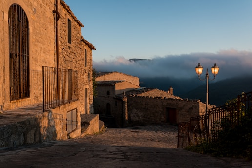a cobblestone street leading to a stone building