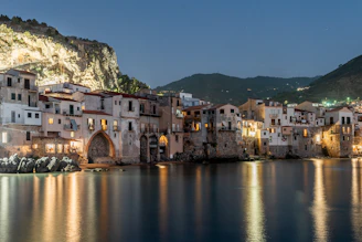 a town on the shore of a lake at night