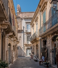 a man sitting on a bench in an alley way