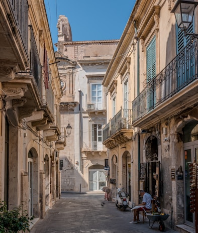 a man sitting on a bench in an alley way