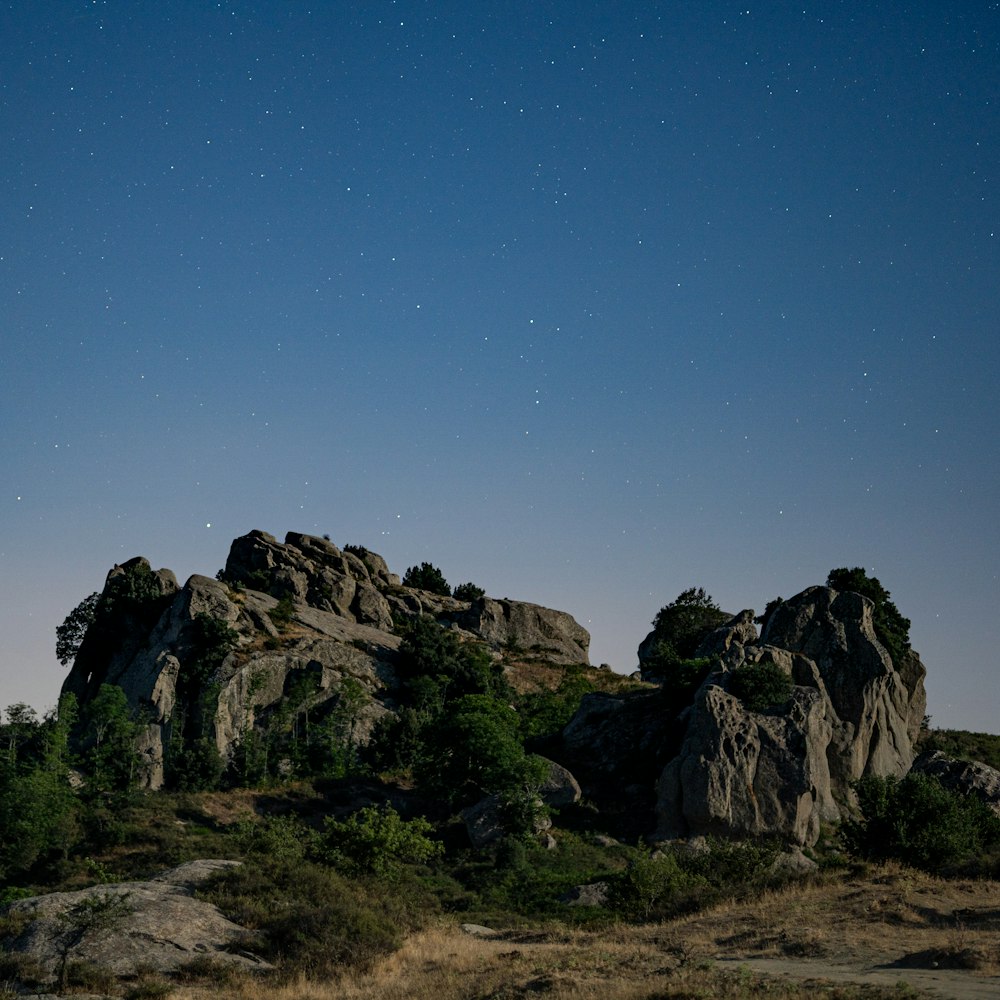 the night sky is full of stars above the rocky terrain