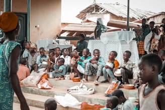 a group of children sitting on steps in front of a building
