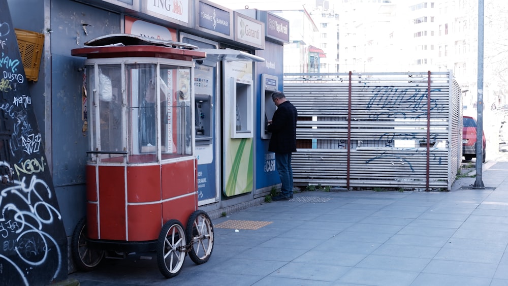 a man standing next to a red and white trolley