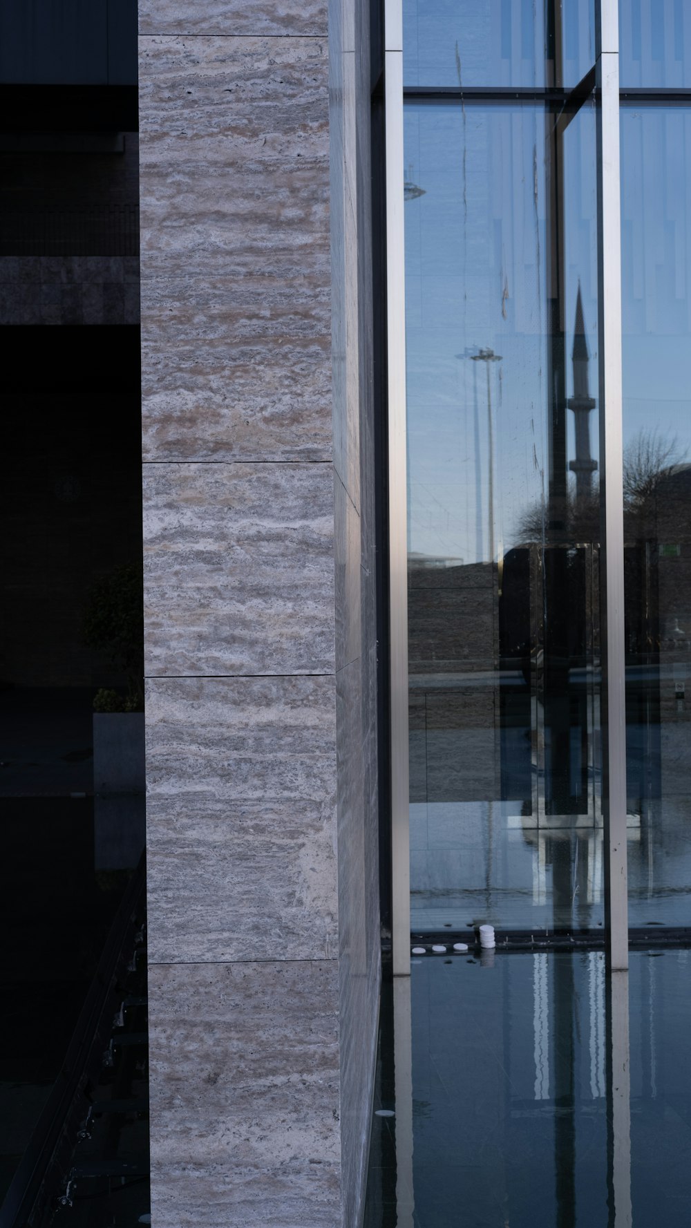 the reflection of a clock tower in the glass of a building