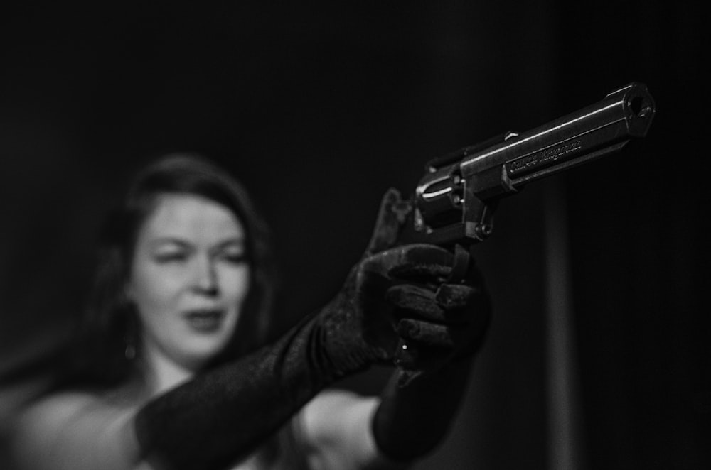 a woman holding a gun in her right hand