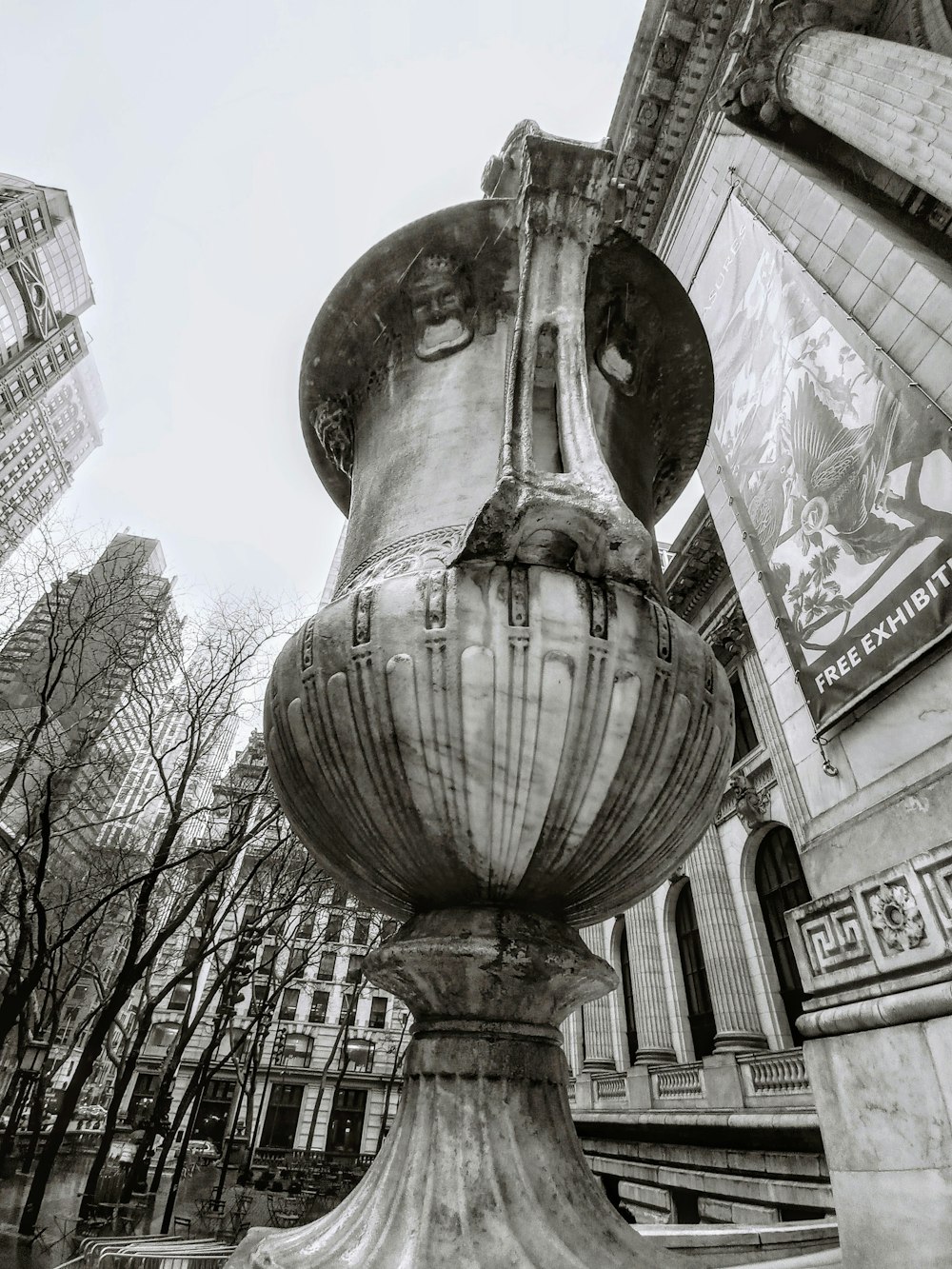 ein Schwarz-Weiß-Foto einer großen Vase vor einem Gebäude