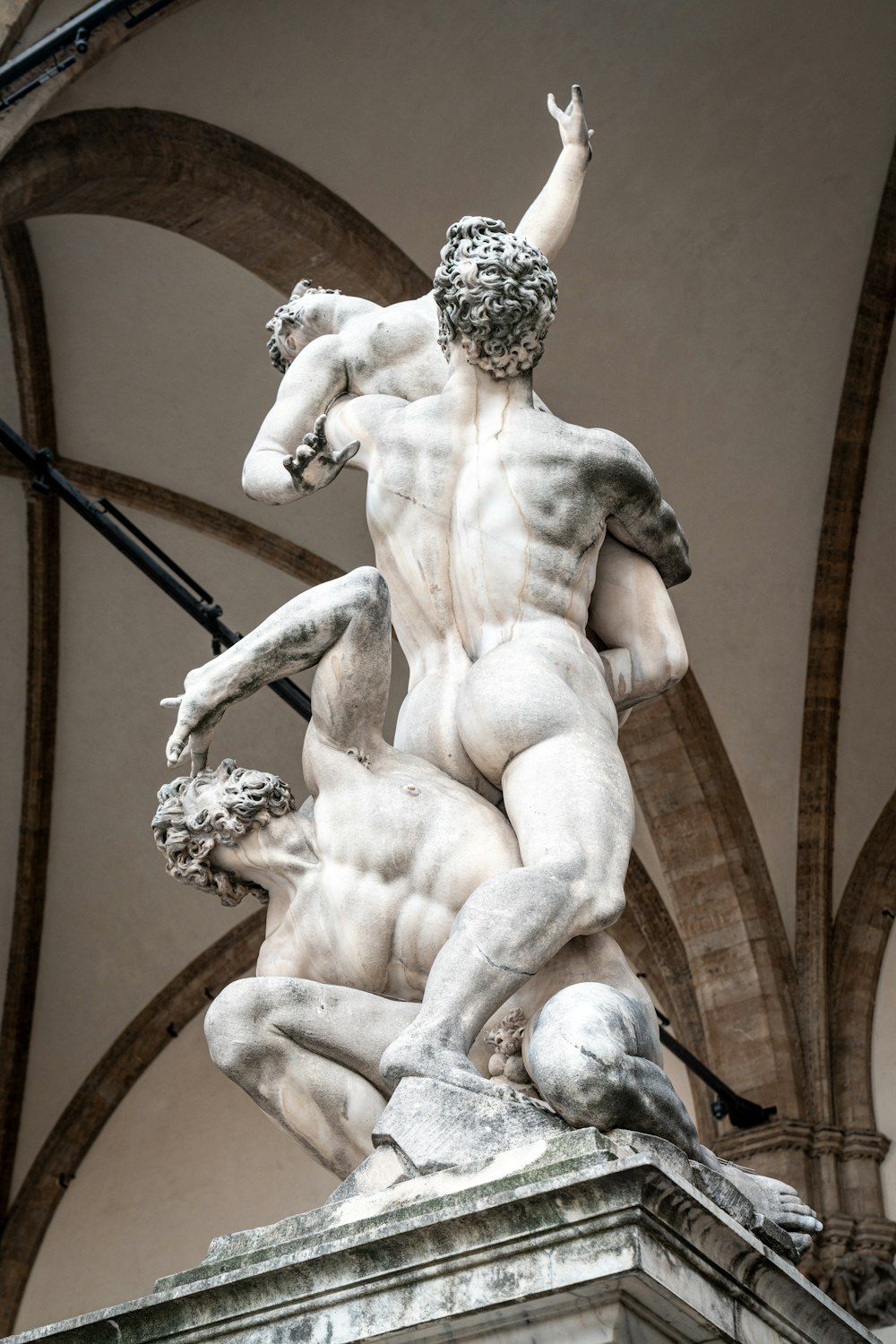 a statue of a man holding a horse in front of a building