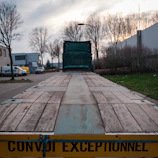 a large flatbed trailer with a yellow sign on it