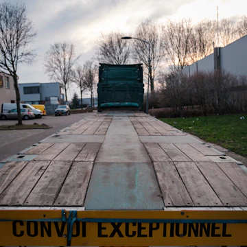 a large flatbed trailer with a yellow sign on it