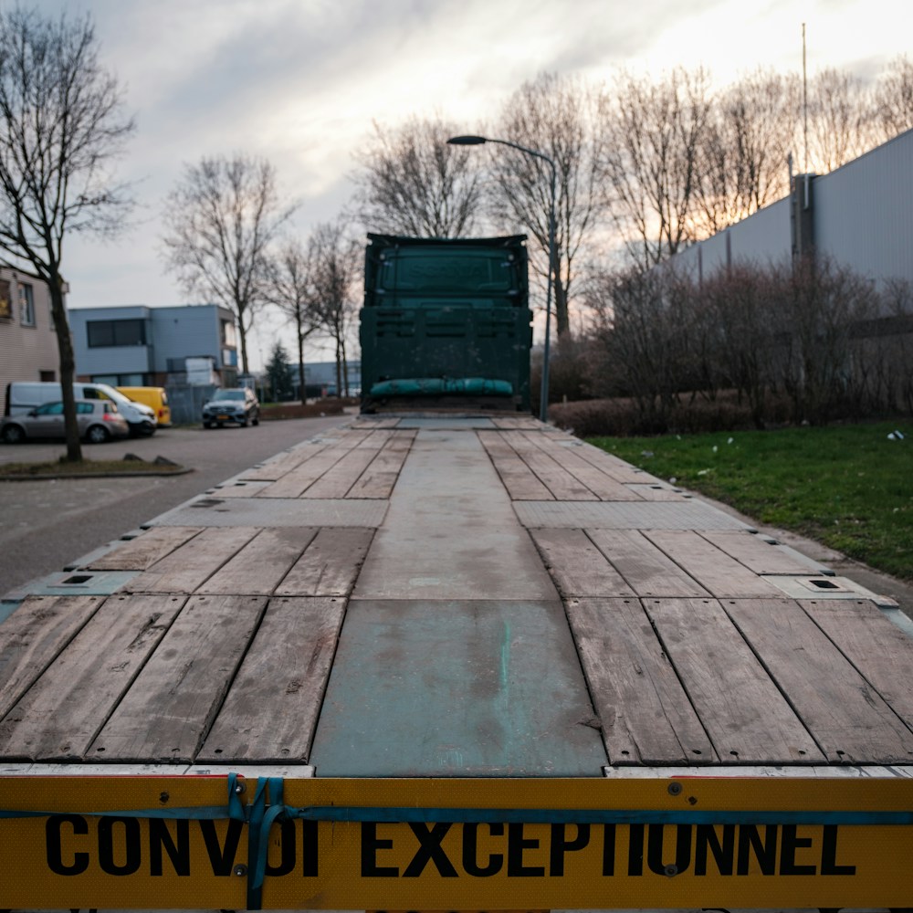 Liels plakanais platformas piekabes vilcējs ar dzeltenu zīmi