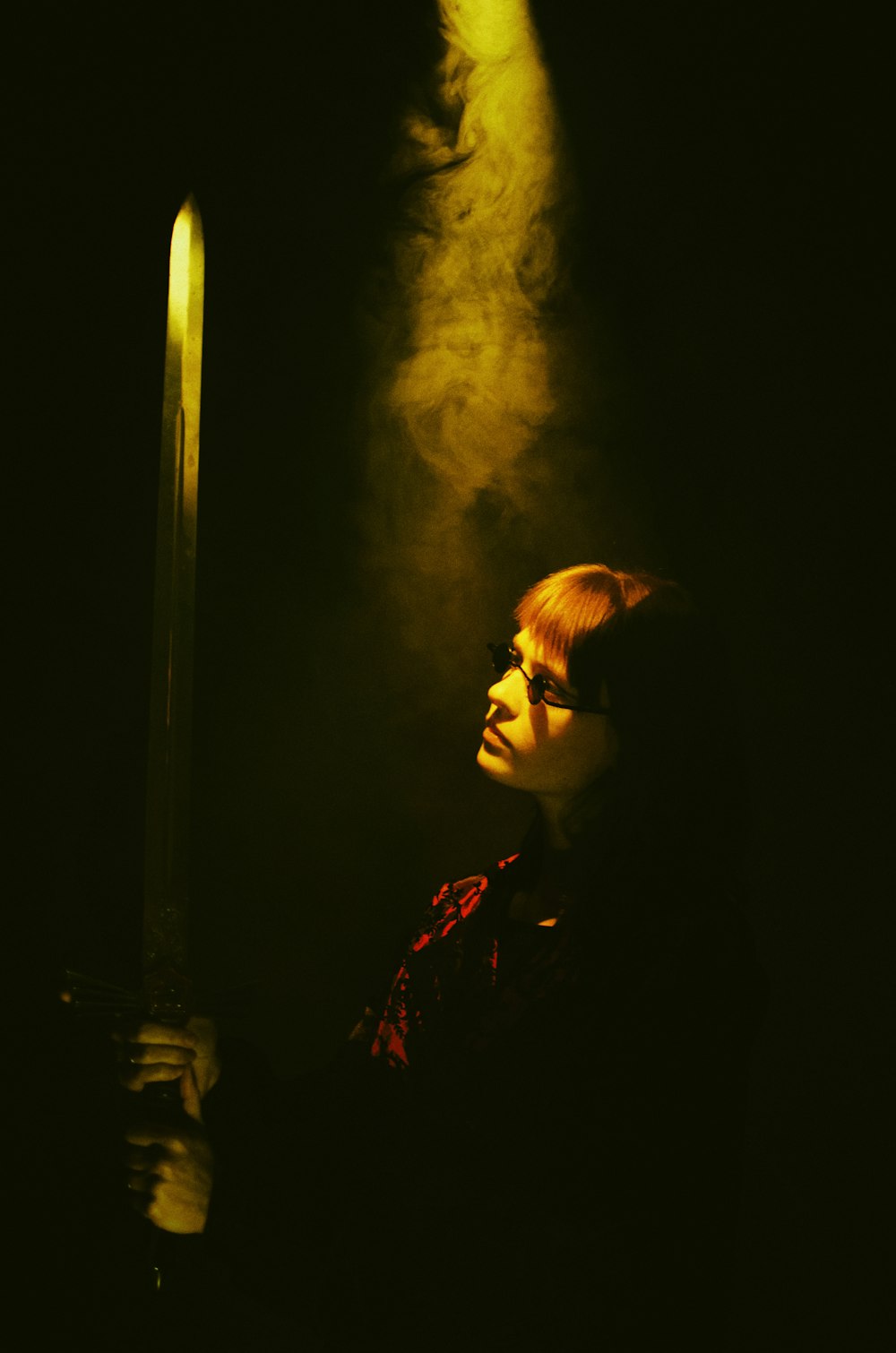 a woman holding a sword in a dark room