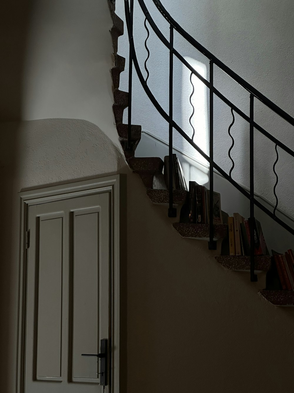 a stair case with a door and books on it