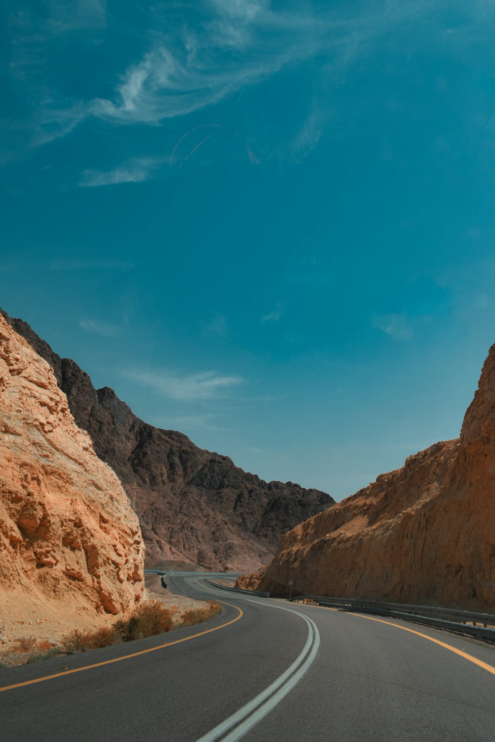 a car driving down a mountain road in the desert