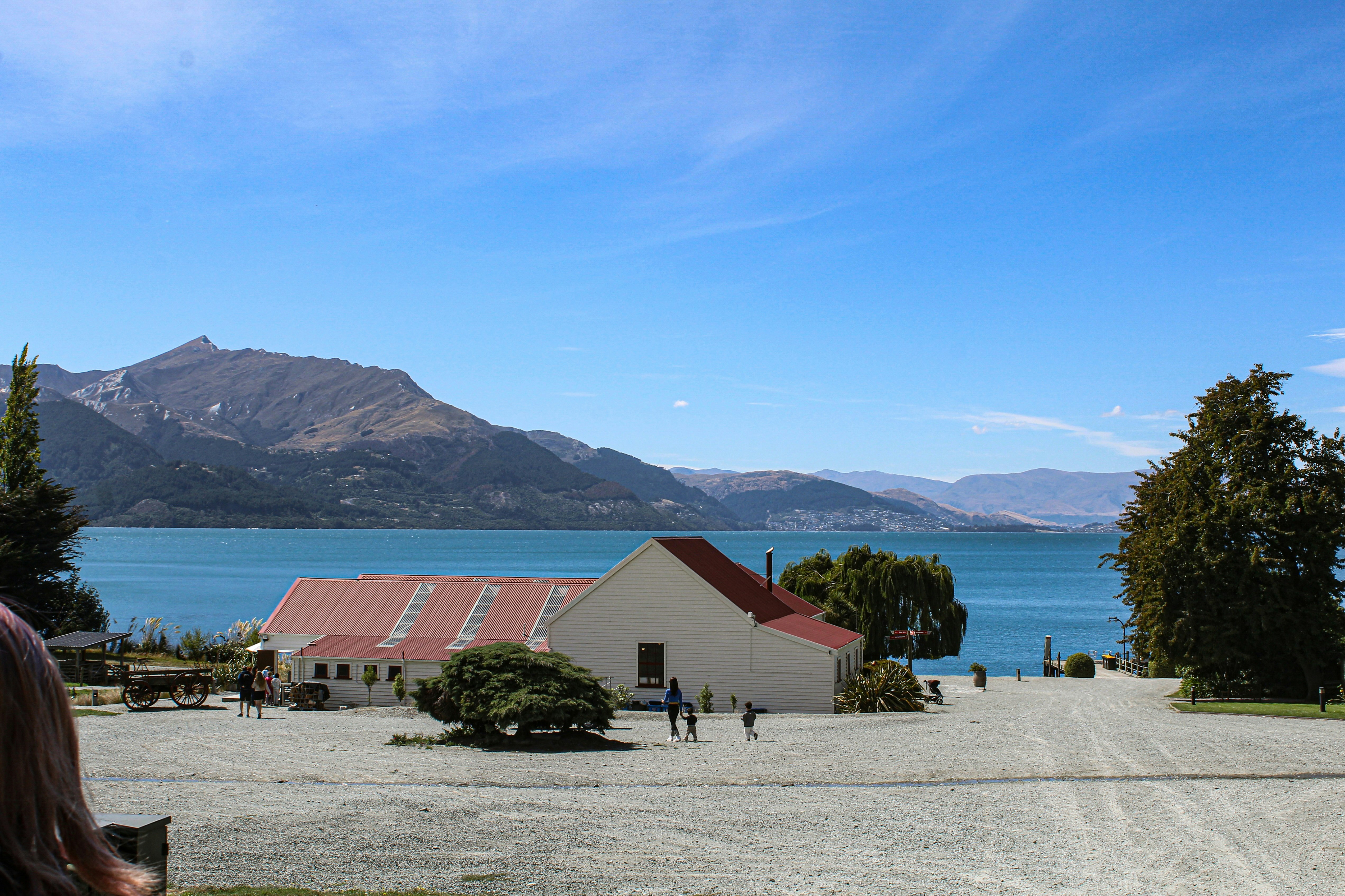 un groupe de personnes debout sur un chemin de terre à côté d’un plan d’eau