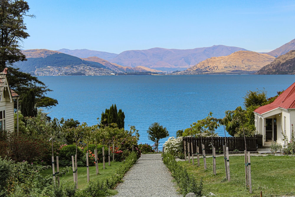 a path leading to a house next to a body of water