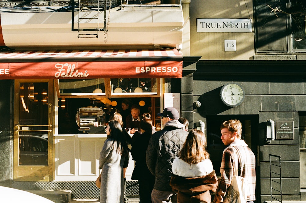 a group of people standing outside of a store