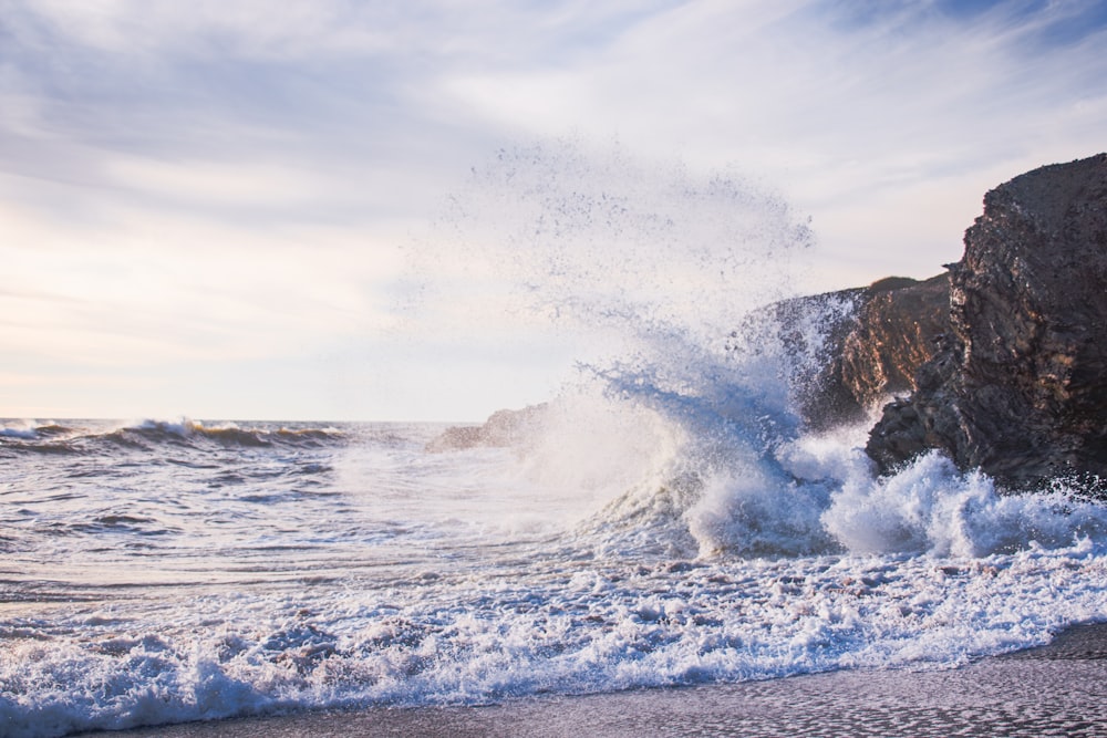 a large wave crashing into the shore of a beach