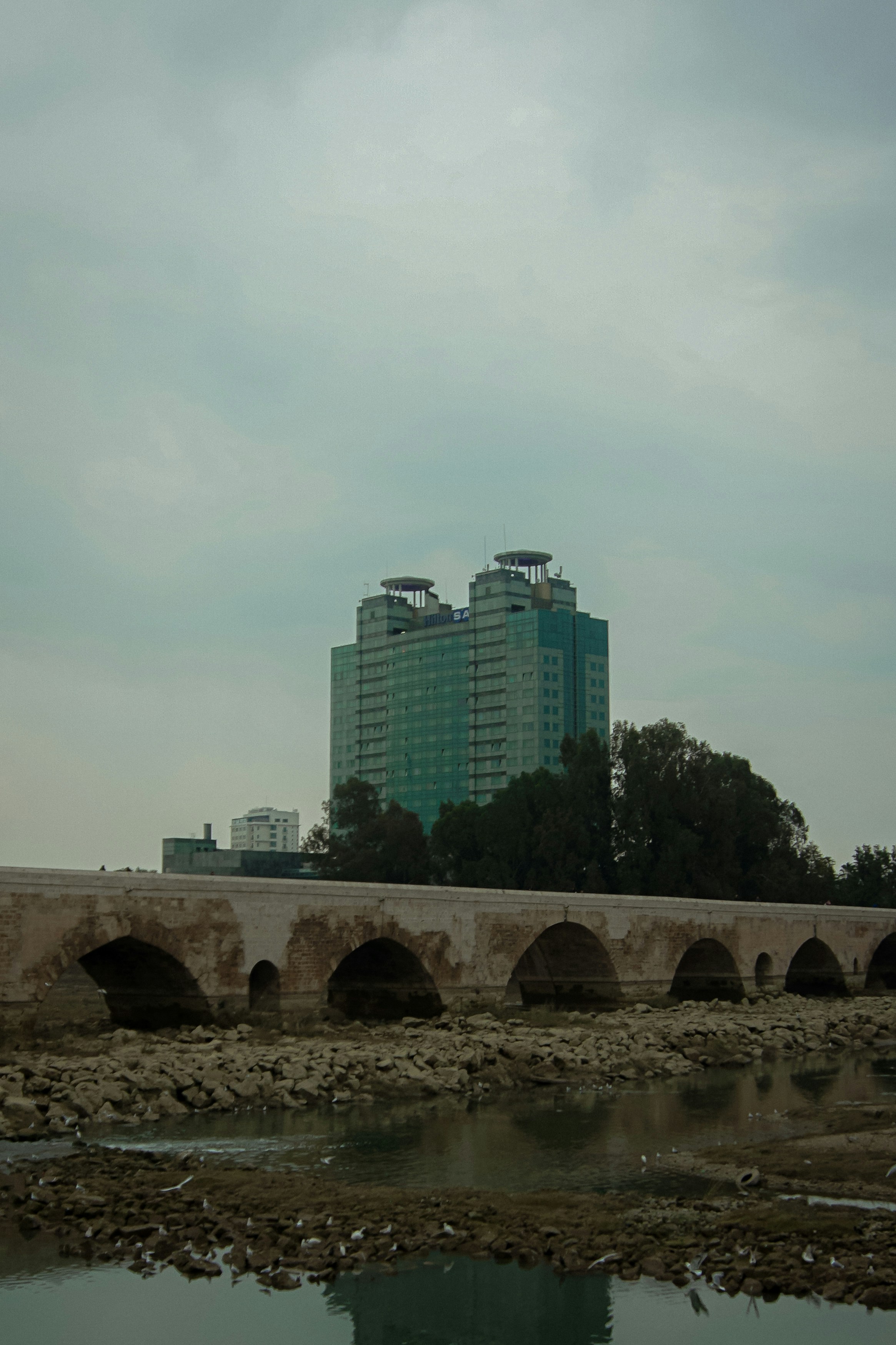 a bridge over a body of water with a building in the background