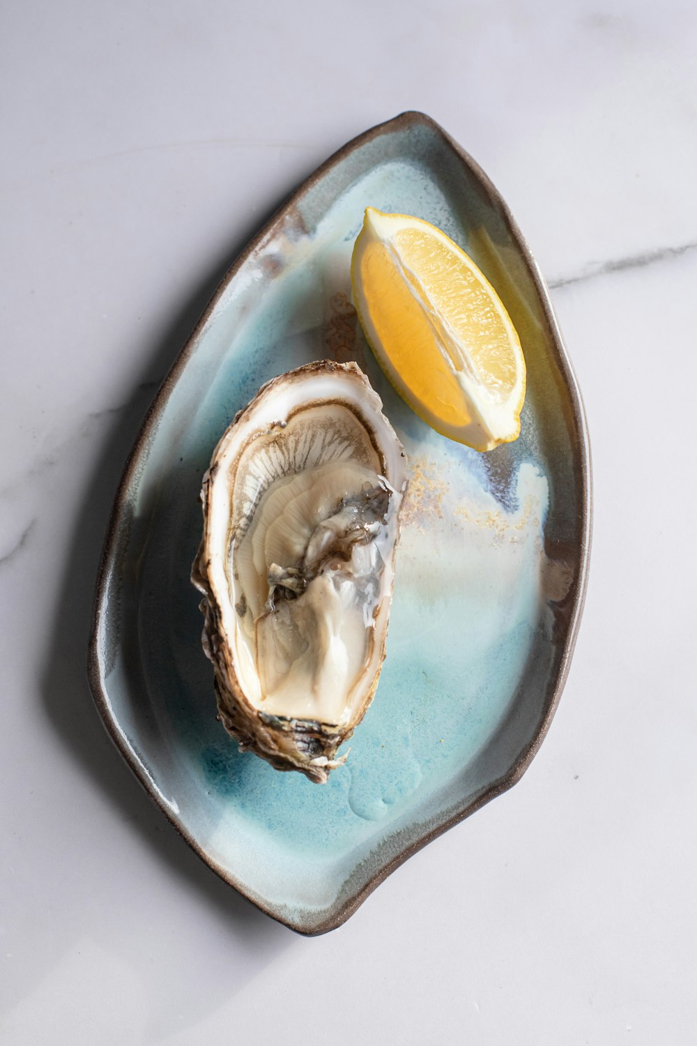 a plate of oysters with a lemon wedge