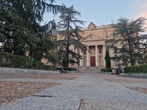 two people sitting on a bench in front of a building